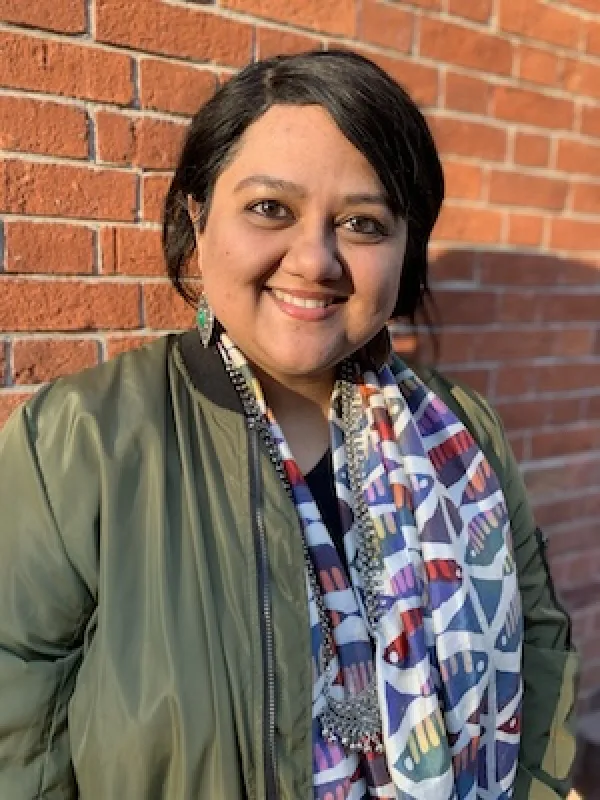 Mukherjee standing in front of brick wall
